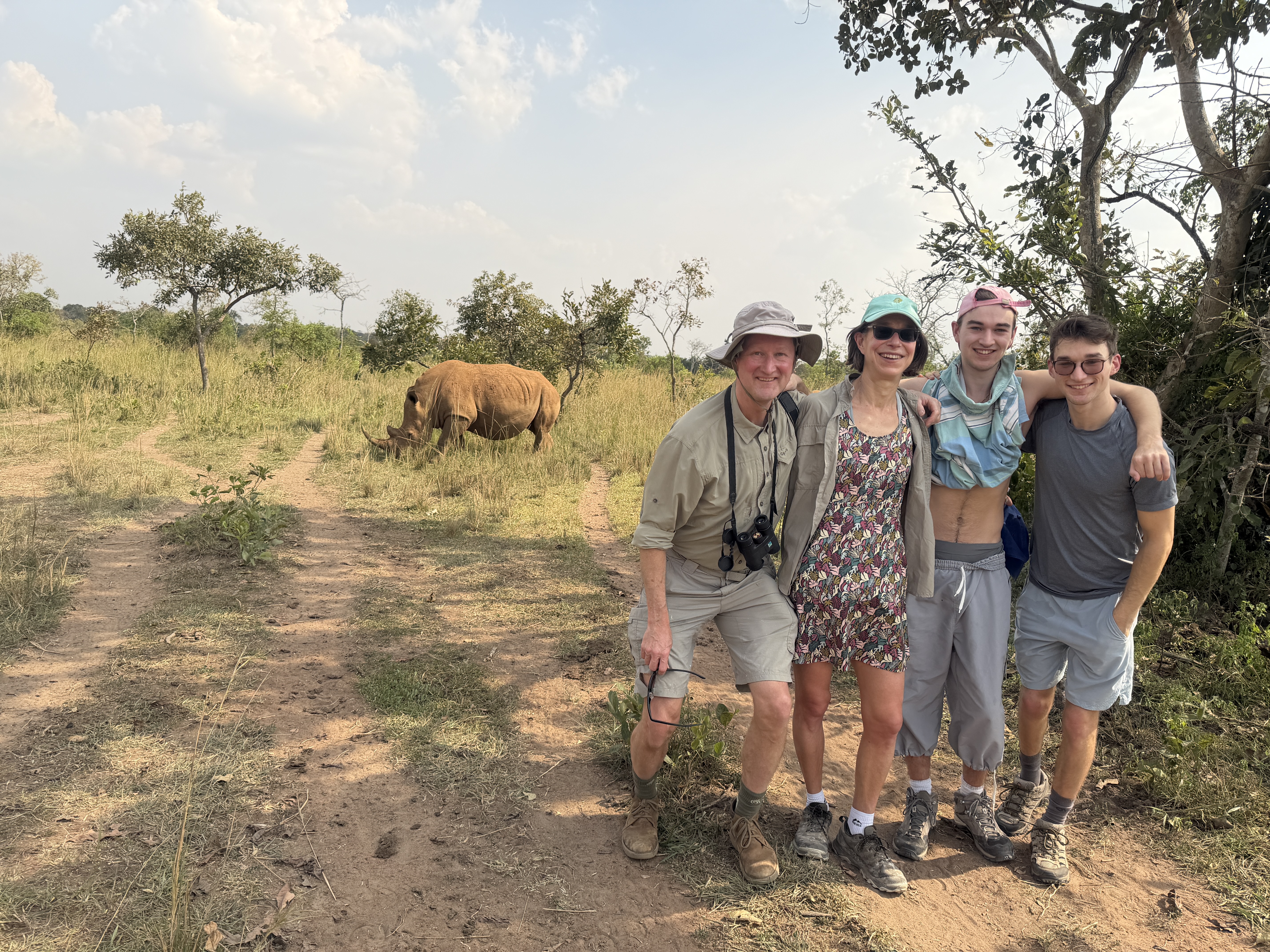 A family safari moment with a rhino in the background.